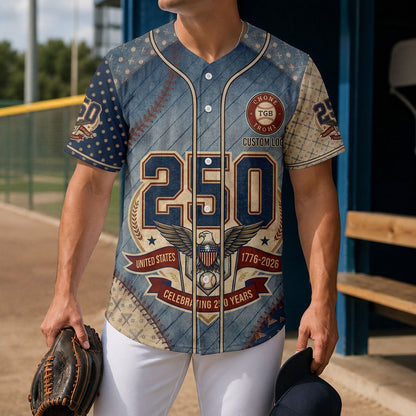 A male model wearing the custom blue textured style USA 250th anniversary baseball jersey standing inside a baseball field dugout holding a glove.