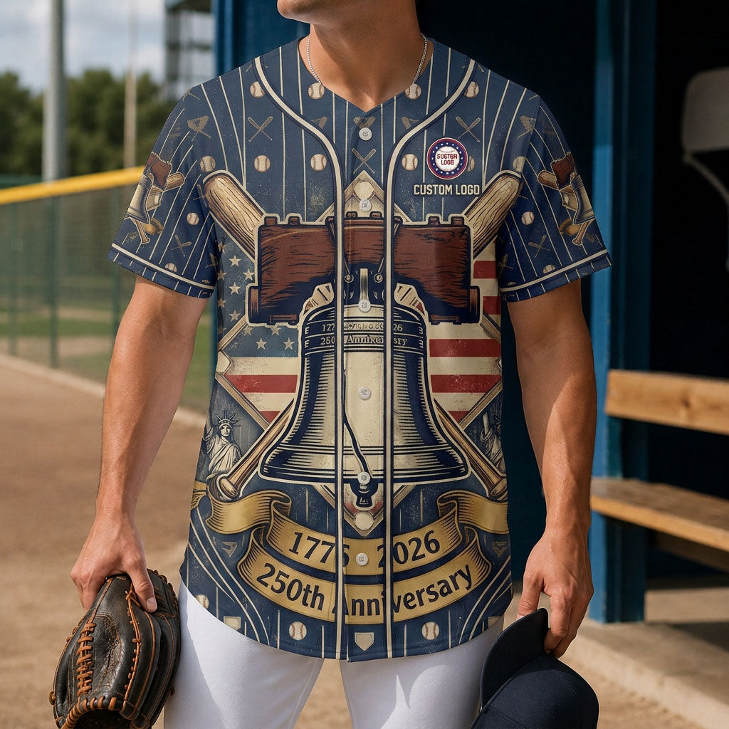 A male model confidently wearing the custom black USA 250 Years of Freedom baseball jersey on a sports field dugout.